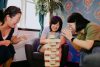 three women playing vividly giant jenga in a colorful background